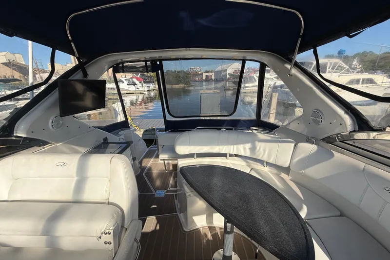 Slide: The Image of Interior of 2005 Regal Commodore 3560 IO yacht with white seating and a mounted TV. - 22