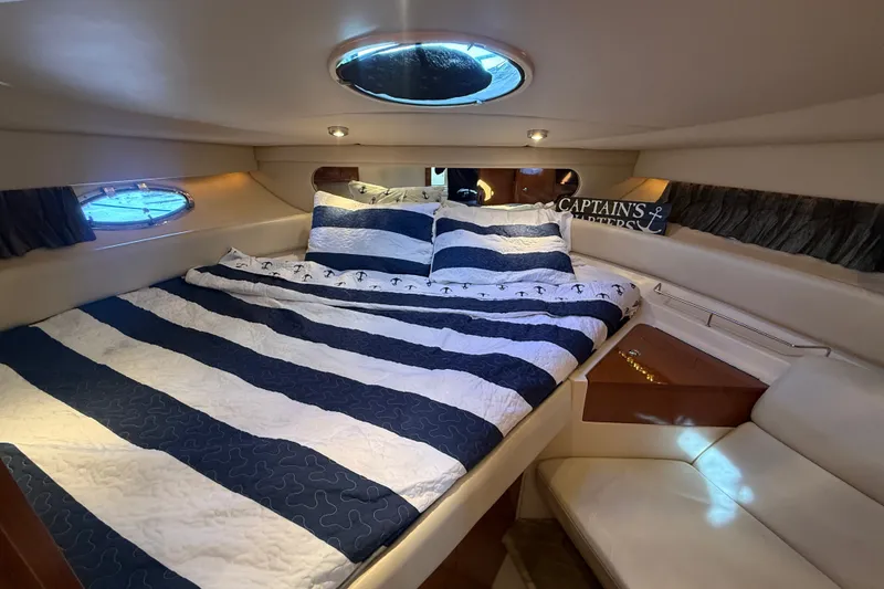 Slide: The Image of Luxurious cabin interior of 2005 Regal Commodore 3560 IO yacht with striped bedding. - 49