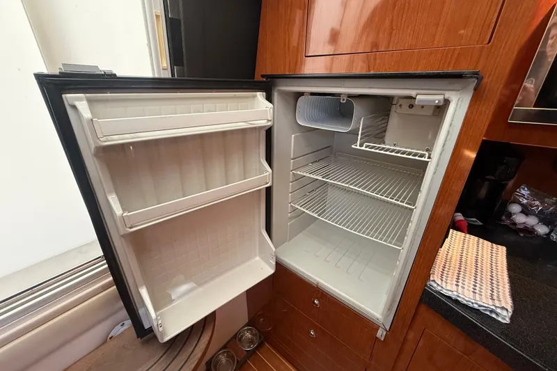 Slide: The Image of Open refrigerator inside 2005 Regal Commodore 3560 IO yacht, showcasing shelves and door storage. - 40