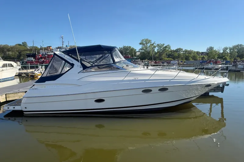 Slide: The Image of 2005 Regal Commodore 3560 IO boat docked in a marina under clear blue skies. - 1