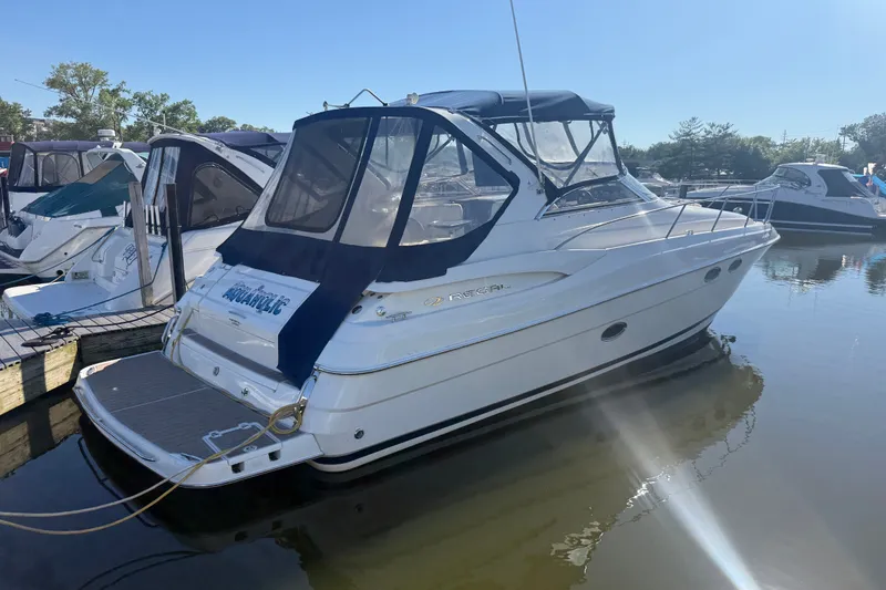 The Image of 2005 Regal Commodore 3560 IO boat docked in a marina under clear blue skies. - 0