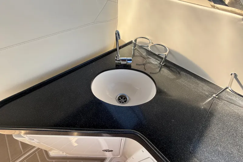 Slide: The Image of 2005 Regal Commodore 3560 IO boat interior with sleek black countertop and sink. - 16