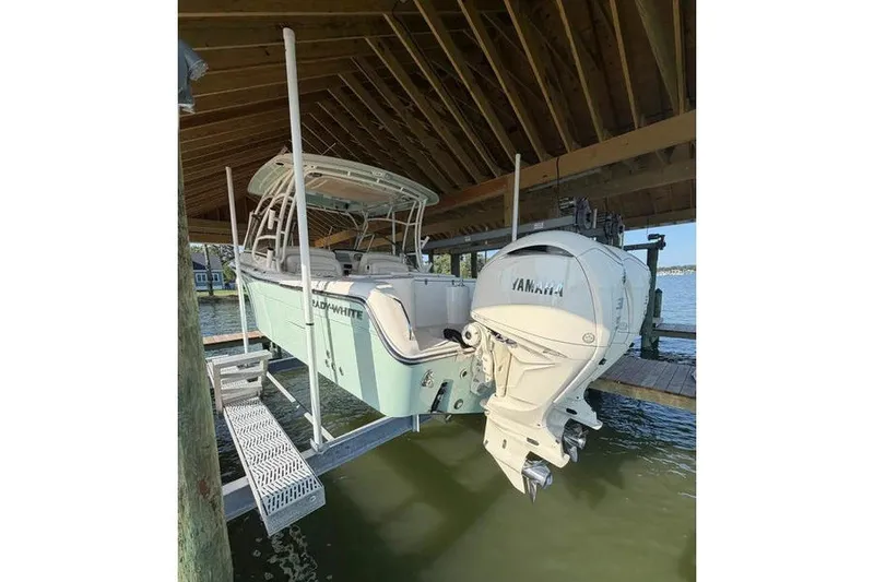 Slide: The Image of 2024 Grady-White Freedom 285 boat with Yamaha engine, docked under a wooden shelter. - 52