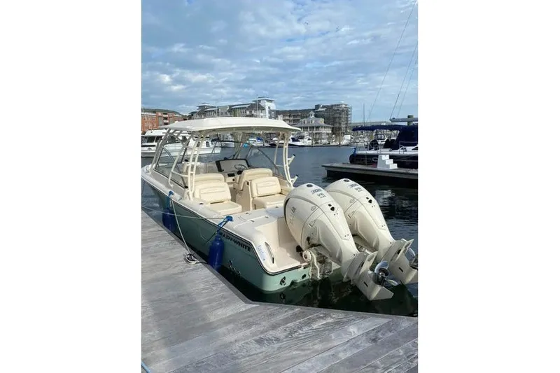 Slide: The Image of 2024 Grady-White Freedom 285 boat docked with twin engines, marina background. - 51