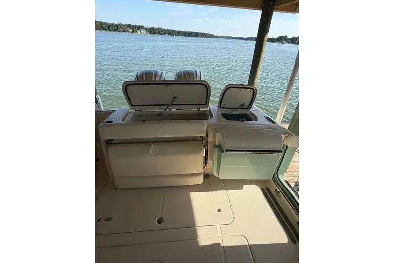 Slide: The Image of 2024 Grady-White Freedom 285 boat interior with open storage compartments by the water. - 13