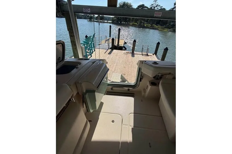 Slide: The Image of 2024 Grady-White Freedom 285 boat interior with dock view and serene water backdrop. - 12
