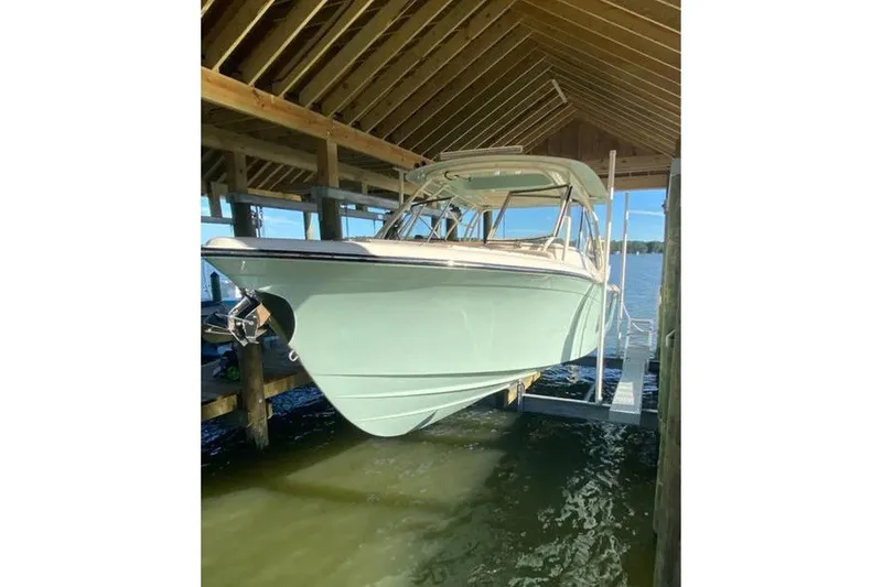 Slide: The Image of 2024 Grady-White Freedom 285 boat docked under a wooden shelter. - 43