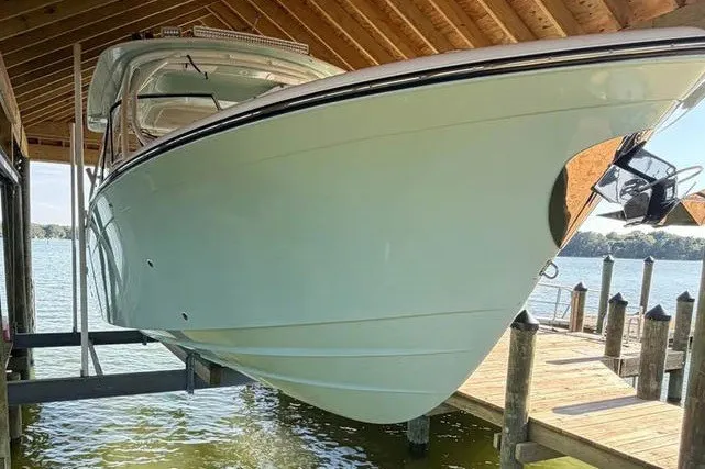 Slide: The Image of 2024 Grady-White Freedom 285 boat docked under a wooden shelter by the water. - 53
