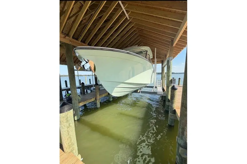 Slide: The Image of 2024 Grady-White Freedom 285 boat docked in a covered marina, side view. - 4