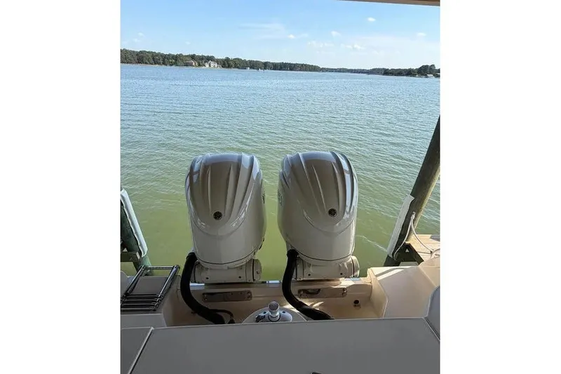 Slide: The Image of 2024 Grady-White Freedom 285 boat with dual outboard motors on a serene lake. - 21