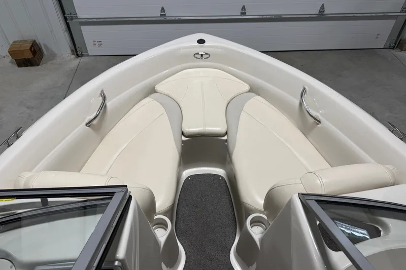 Slide: The Image of Interior of a 2010 Tahoe Q5i Sport boat with white seating and gray flooring. - 10