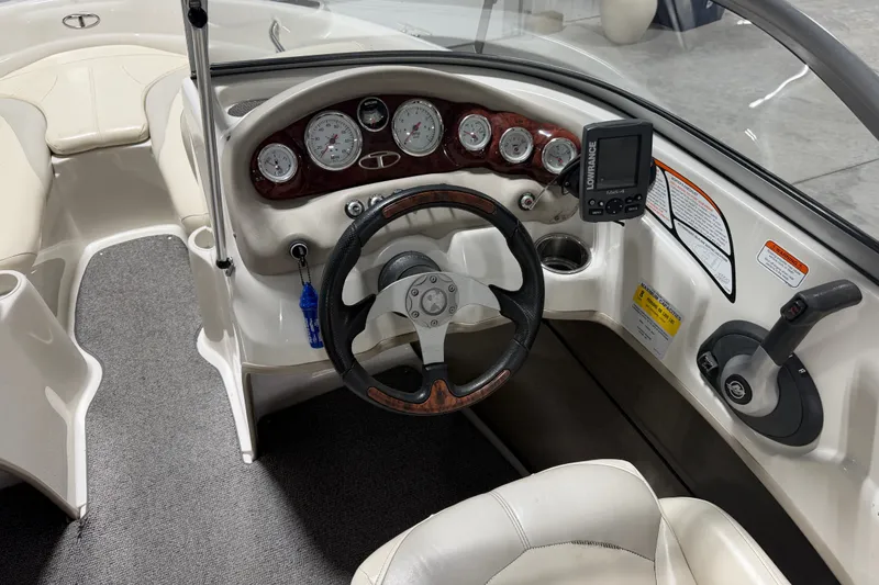 Slide: The Image of 2010 Tahoe Q5i Sport boat dashboard with steering wheel and gauges. - 8