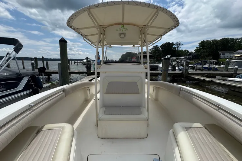 Slide: The Image of 2003 Scout 280 Sportfish boat docked at a marina under a cloudy sky. - 16