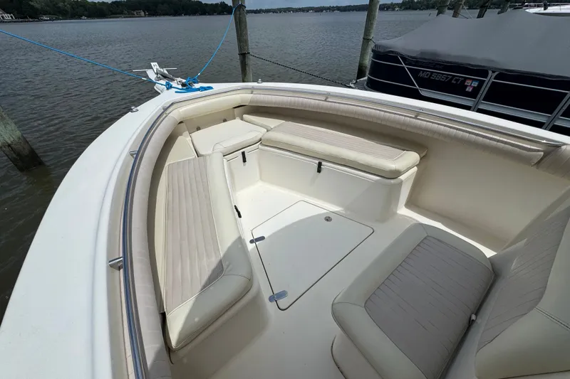 Slide: The Image of 2003 Scout 280 Sportfish boat interior with cushioned seating and storage compartments. - 14