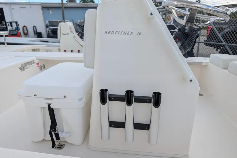 Slide: The Image of The image shows the cockpit of a 2027 Hewes Redfisher 16 with fishing rod holders. - 12