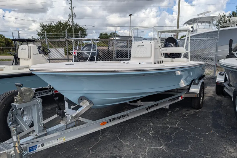 Slide: The Image of A light blue boat on a trailer, featuring a console and an outboard motor. - 1