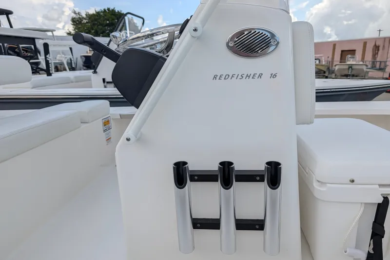 Slide: The Image of The image shows the console of a Hewes Redfisher 16 boat with rod holders. - 11