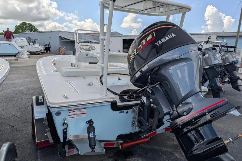 Slide: The Image of A Hewes Redfisher 16 boat with a Yamaha outboard motor, parked on an asphalt lot. - 4