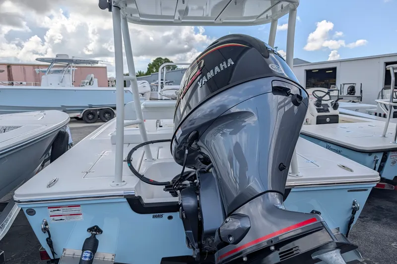 Slide: The Image of A 2027 Hewes Redfisher 16 boat with a Yamaha outboard motor, parked in a marina area. - 5
