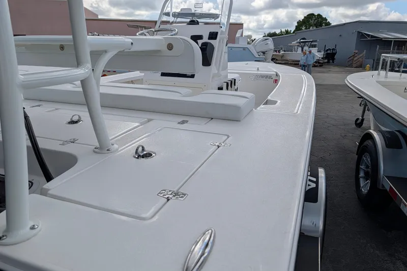 Slide: The Image of A modern boat with a white deck and multiple storage compartments, situated in a dock area. - 7
