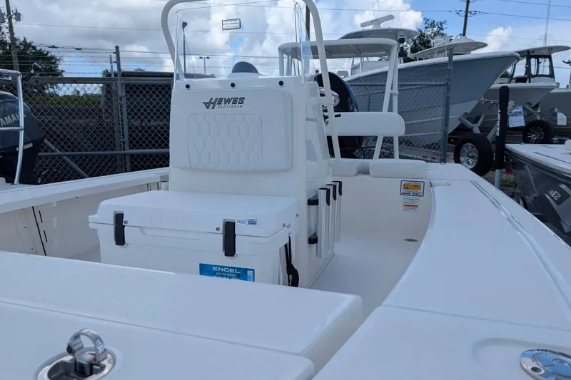 Slide: The Image of The image shows a 2027 Hewes Redfisher 16 boat. It features a clean, white deck and a central console. - 13