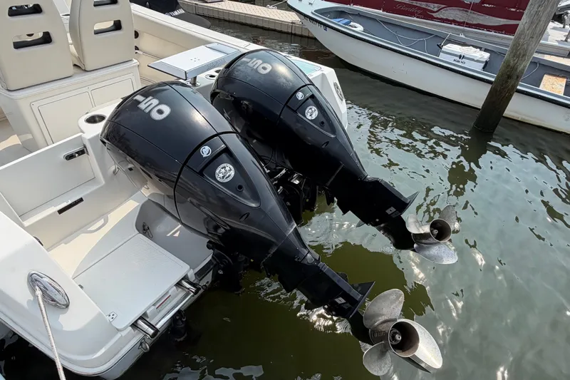 Slide: The Image of Twin outboard engines on a 2022 Sailfish 242 CC boat docked in marina. - 4