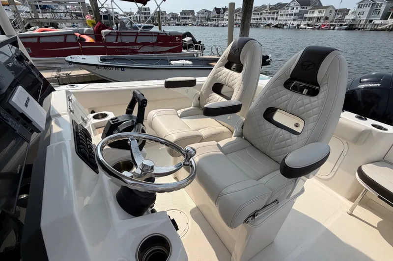 Slide: The Image of Luxury seating on 2022 Sailfish 242 CC boat, featuring modern helm and waterfront view. - 22