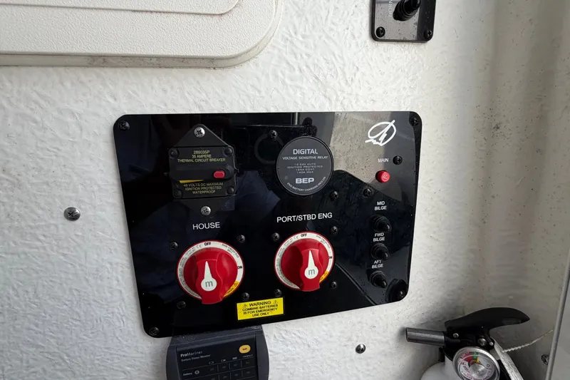 Slide: The Image of Control panel of a 2022 Sailfish 242 CC boat with circuit breakers and switches. - 11