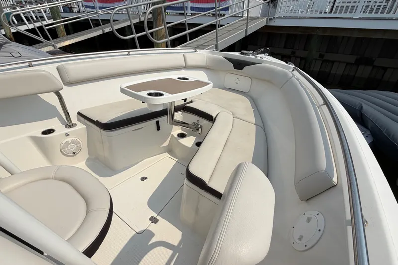 Slide: The Image of 2022 Sailfish 242 CC boat interior with seating and table at dock. - 9