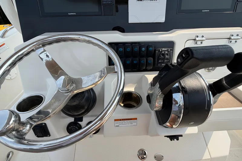 Slide: The Image of Steering wheel and controls of 2022 Sailfish 242 CC boat cockpit. - 13