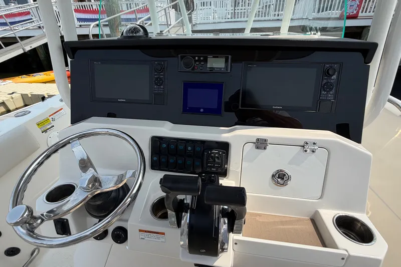Slide: The Image of 2022 Sailfish 242 CC boat dashboard with steering wheel and navigation controls. - 18