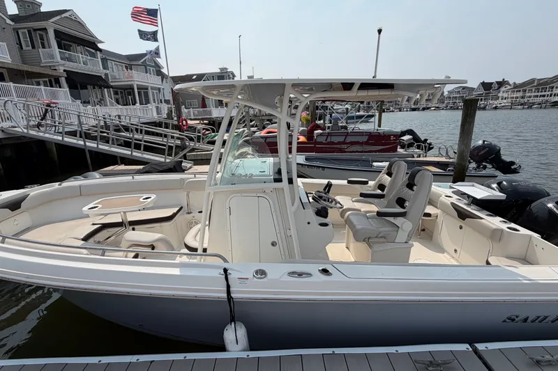 Slide: The Image of 2022 Sailfish 242 CC boat docked at marina, featuring spacious seating and modern design. - 1