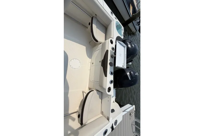 Slide: The Image of 2022 Sailfish 242 CC boat interior with dual engines at dock. - 21