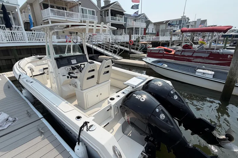 Slide: The Image of 2022 Sailfish 242 CC boat docked, featuring dual outboard engines and modern design. - 3