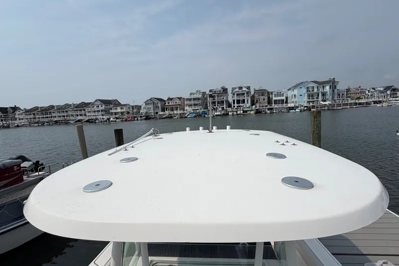 Slide: The Image of 2022 Sailfish 242 CC boat docked with waterfront homes in the background. - 10