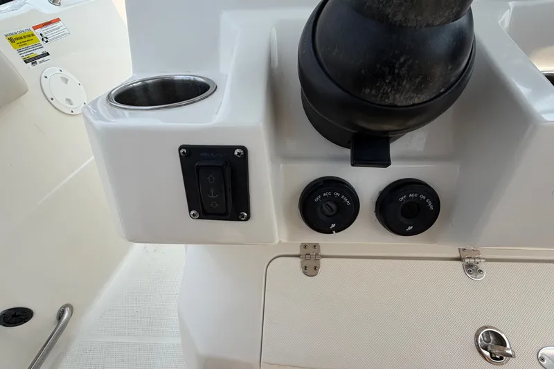 Slide: The Image of Control panel of 2022 Sailfish 242 CC boat with switches and cup holder. - 12