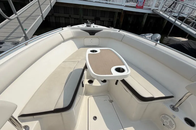 Slide: The Image of 2022 Sailfish 242 CC boat interior with cushioned seating and table. - 20