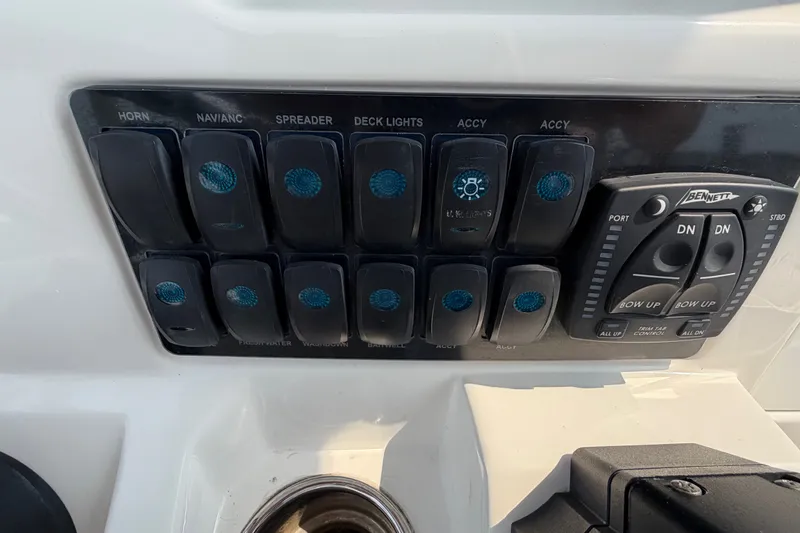 Slide: The Image of Control panel of a 2022 Sailfish 242 CC boat with labeled switches and trim tab controls. - 15