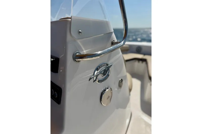 Slide: The Image of 2022 Tidewater 1910 Bay Max boat console with logo and railing, ocean in background. - 24