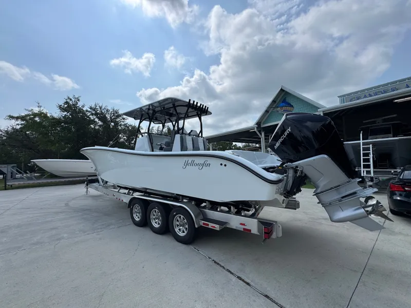 Slide: The Image of 2027 Yellowfin 34 Offshore boat on trailer, parked outdoors under cloudy sky. - 19