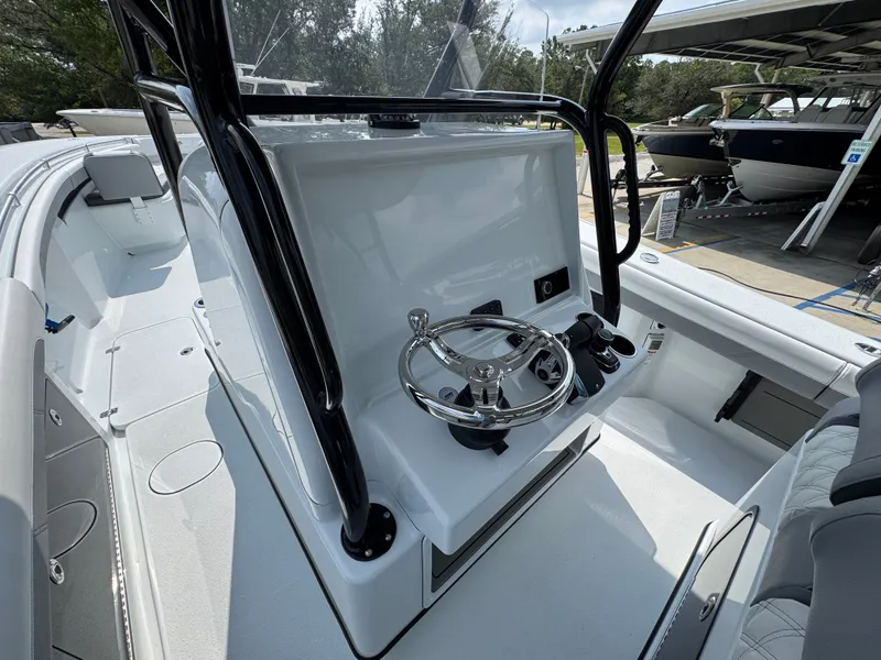 Slide: The Image of 2027 Yellowfin 34 Offshore boat cockpit with steering wheel and controls, docked outdoors. - 36
