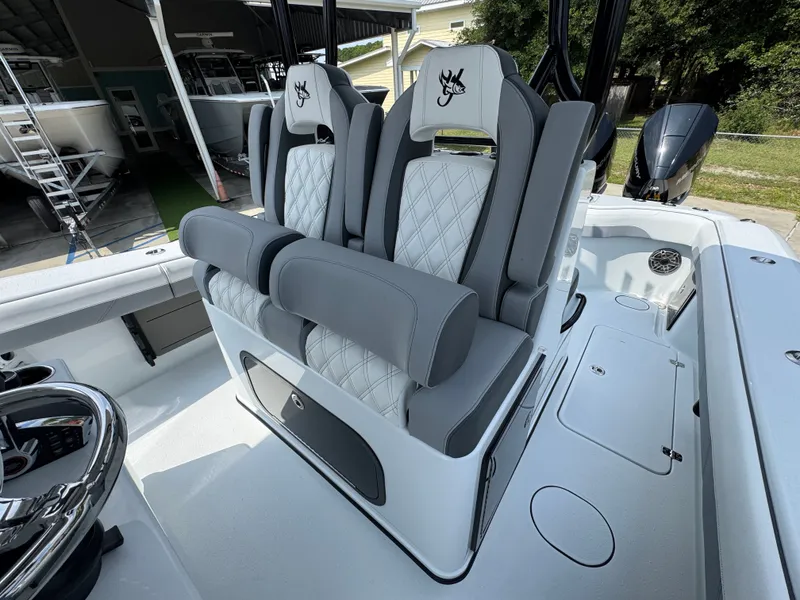 Slide: The Image of 2027 Yellowfin 34 Offshore boat with luxurious gray and white seating in a marina setting. - 32