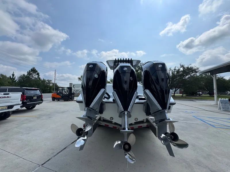 Slide: The Image of 2027 Yellowfin 34 Offshore boat with triple outboard engines in a parking lot. - 16