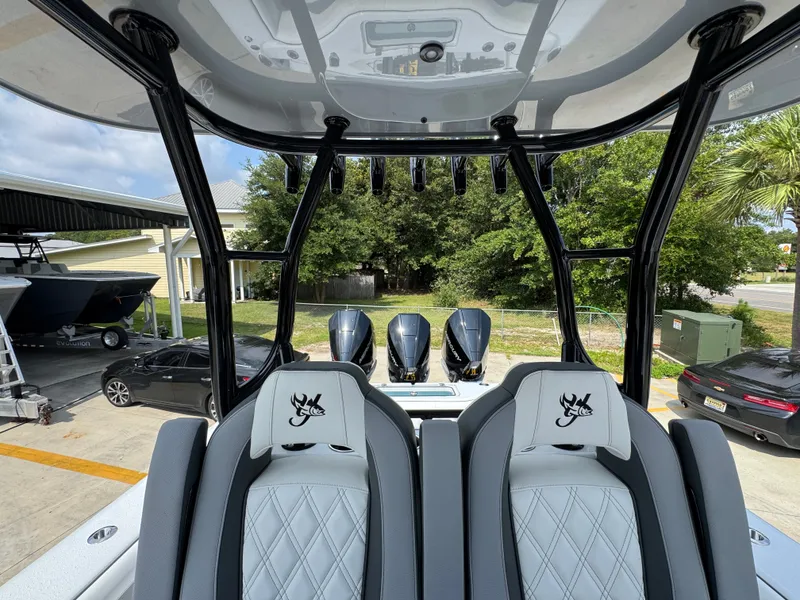 Slide: The Image of 2027 Yellowfin 34 Offshore boat interior with triple outboard engines and luxury seating. - 34