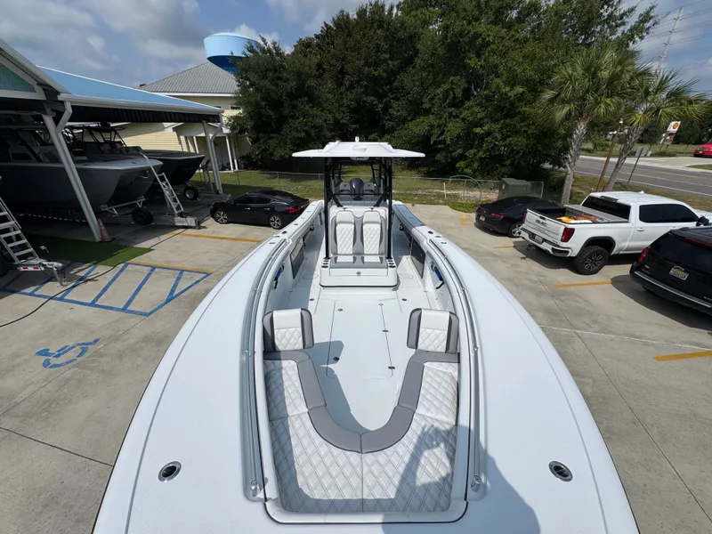 Slide: The Image of 2027 Yellowfin 34 Offshore boat in parking lot, showcasing sleek design and spacious deck. - 25