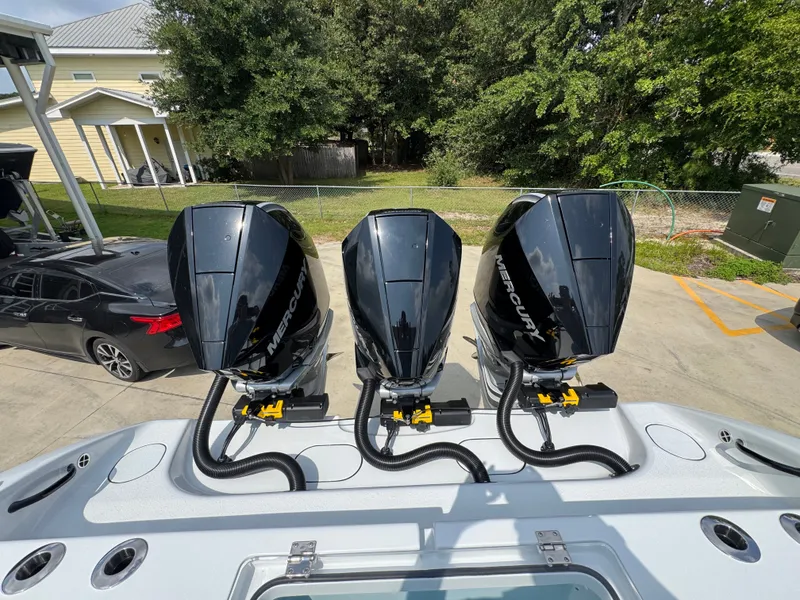 Slide: The Image of 2027 Yellowfin 34 Offshore boat with triple Mercury outboard engines in a driveway setting. - 48