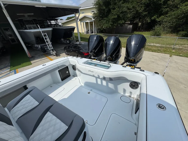 Slide: The Image of 2027 Yellowfin 34 Offshore boat with triple Mercury engines in a marina setting. - 45