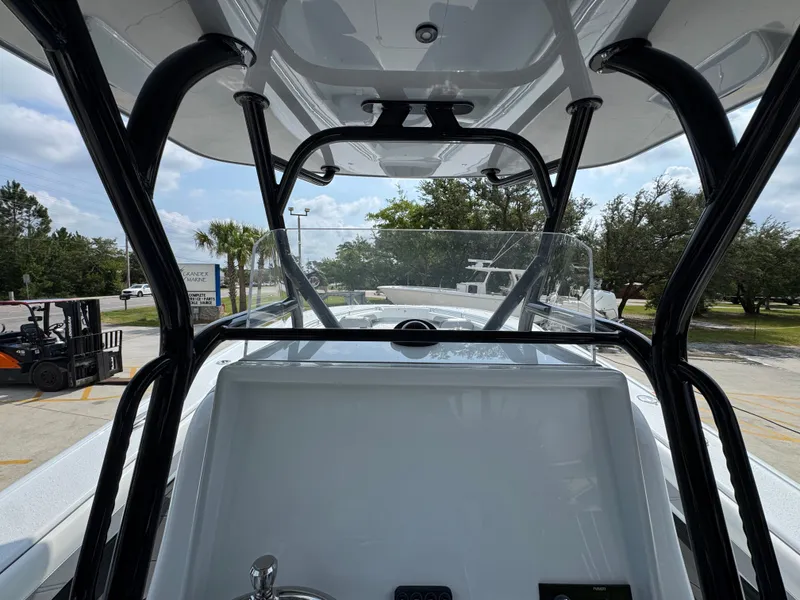Slide: The Image of 2027 Yellowfin 34 Offshore boat interior with console and windshield, parked outdoors. - 38
