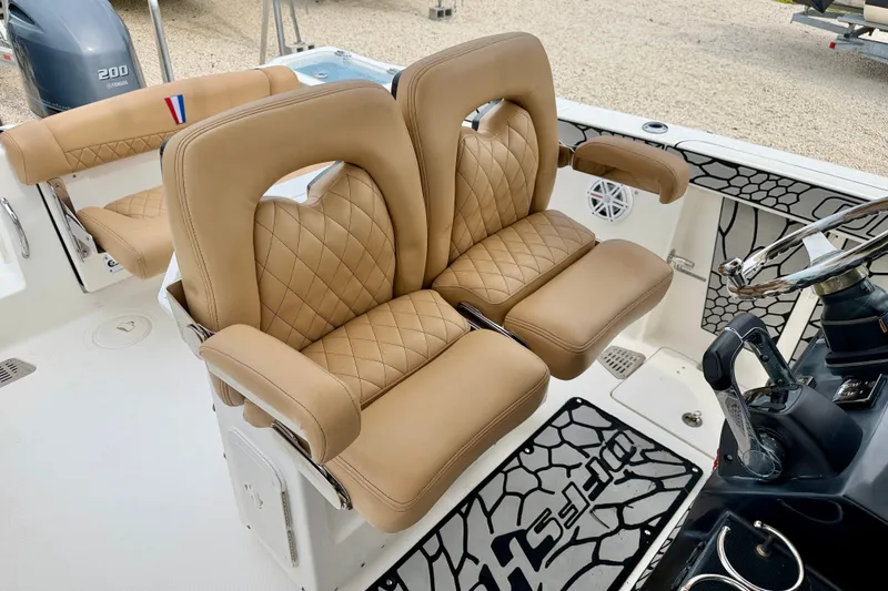 Slide: The Image of Luxurious tan seating on 2019 Wellcraft 262 Fisherman boat, featuring diamond stitching and armrests. - 19