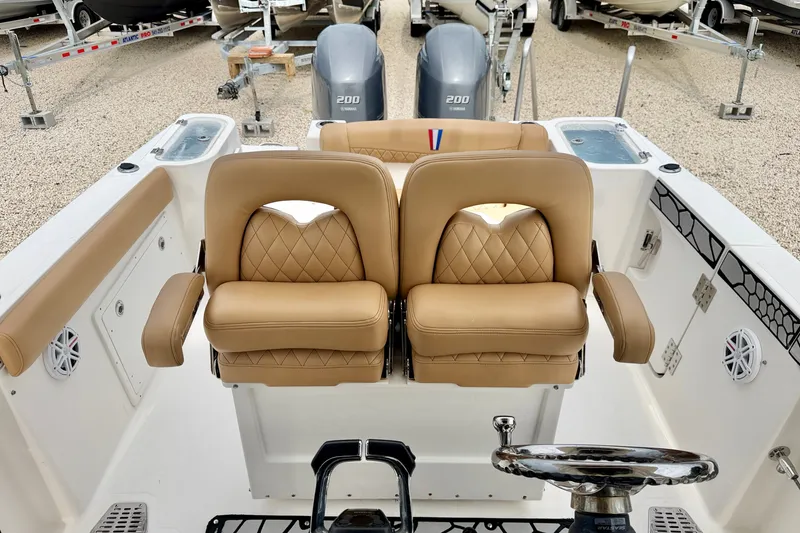 Slide: The Image of 2019 Wellcraft 262 Fisherman boat interior with tan leather seats and dual engines. - 20